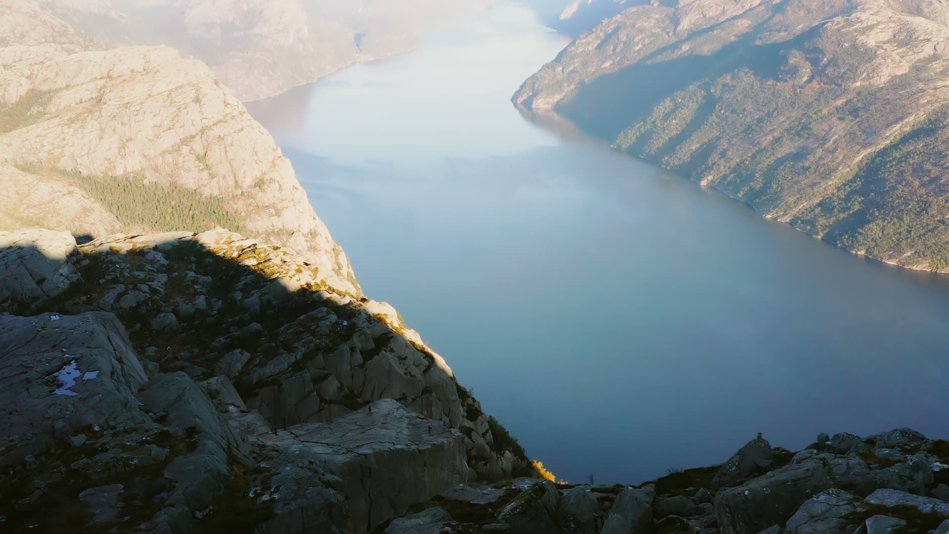Cliff edge above narrow fjord, low sun, Preikestolen, Norway