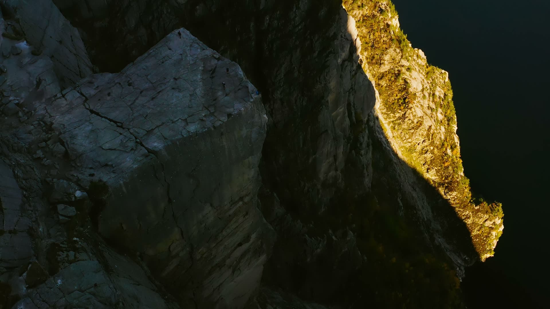Sunlit cliff edge above shadowed rock face, Preikestolen, Norway