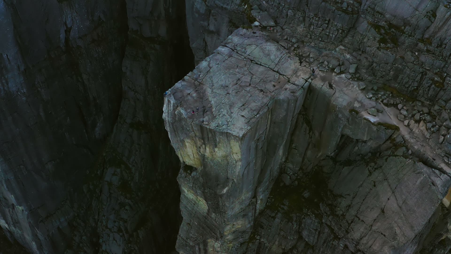 Flat cliff plateau above shadowed chasm, Preikestolen, Norway