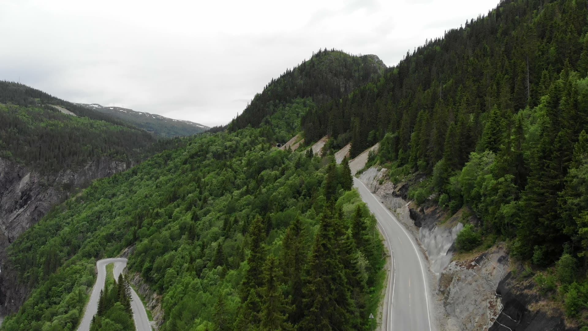 Winding cliffside road toward tunnel mouth, Rjukan, Norway