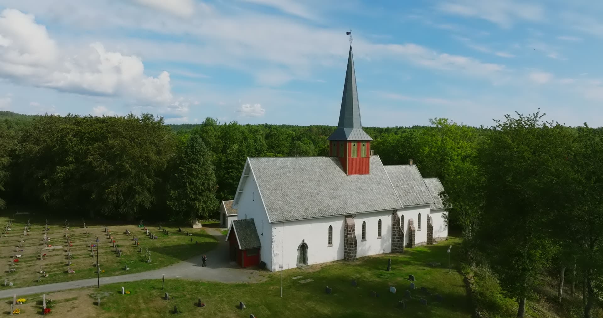 Orbit past church gable to gravel cemetery path, Rykene, Norway