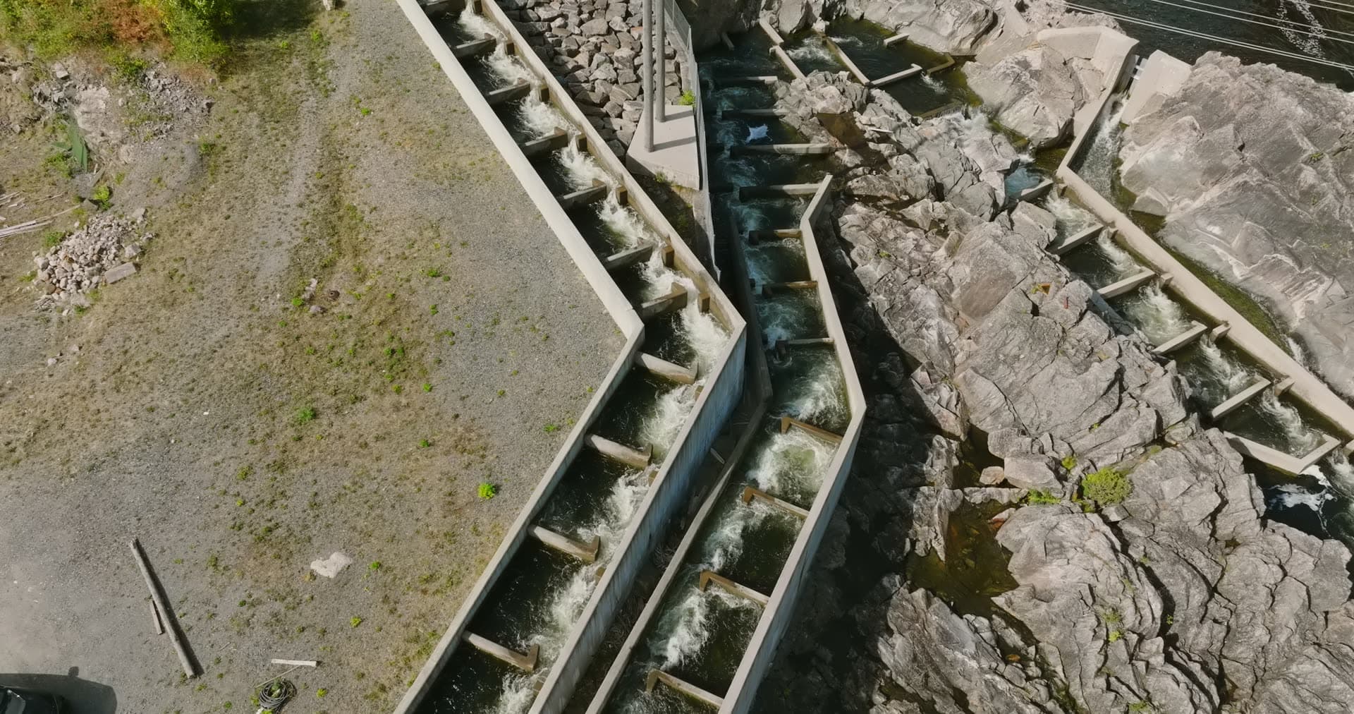 Concrete fish ladder steps beside bedrock, Rykene, Norway