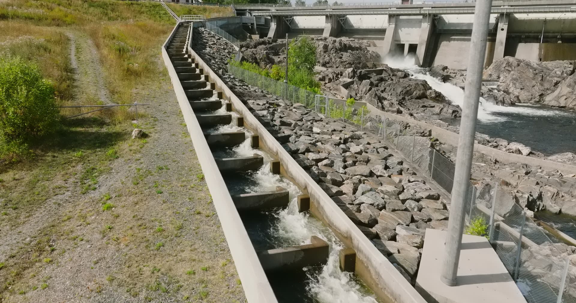 Concrete fish ladder beside dam spillway, Rykene, Norway