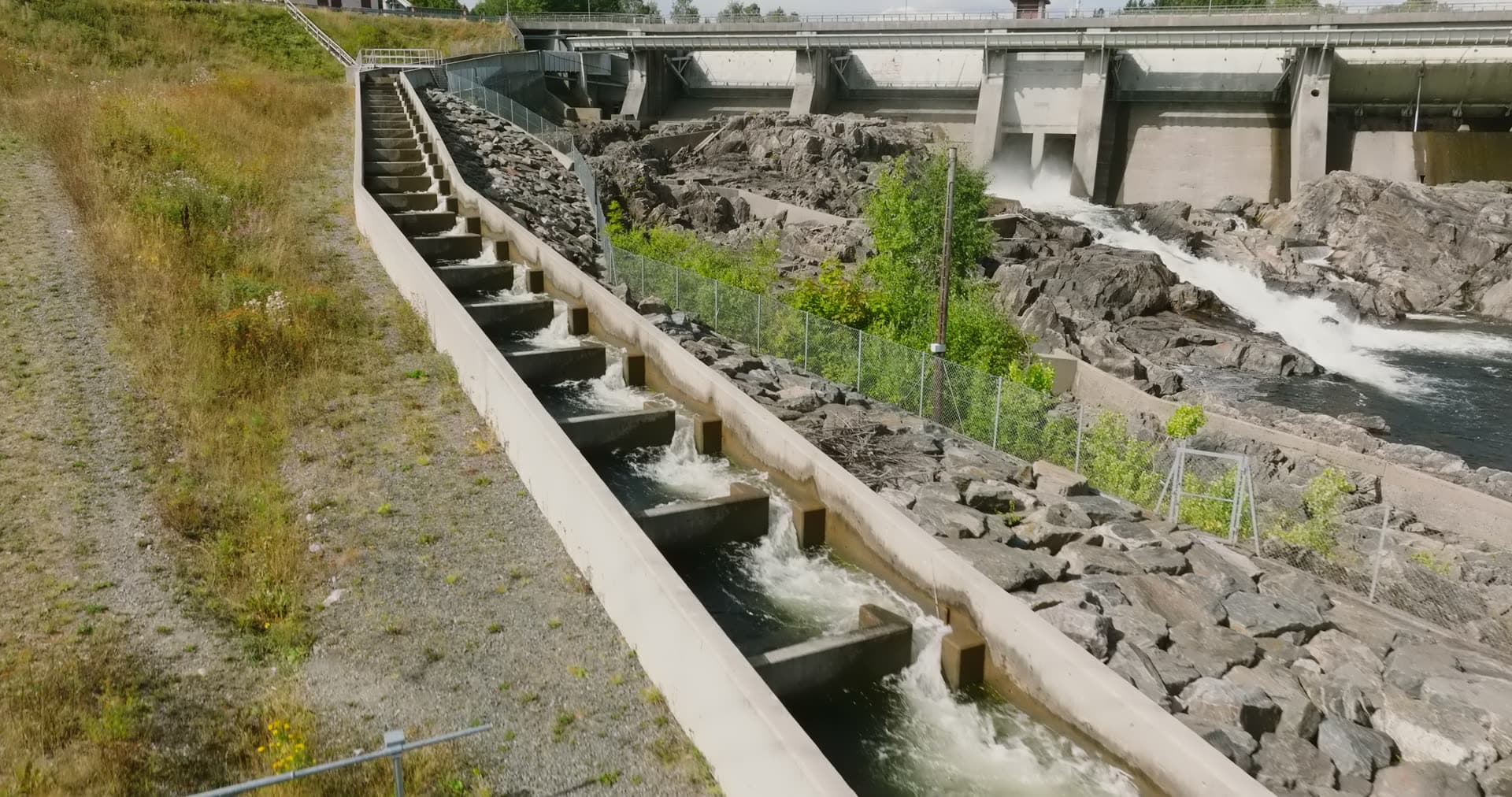 Concrete salmon ladder beside dam spillway, Rykene, Norway