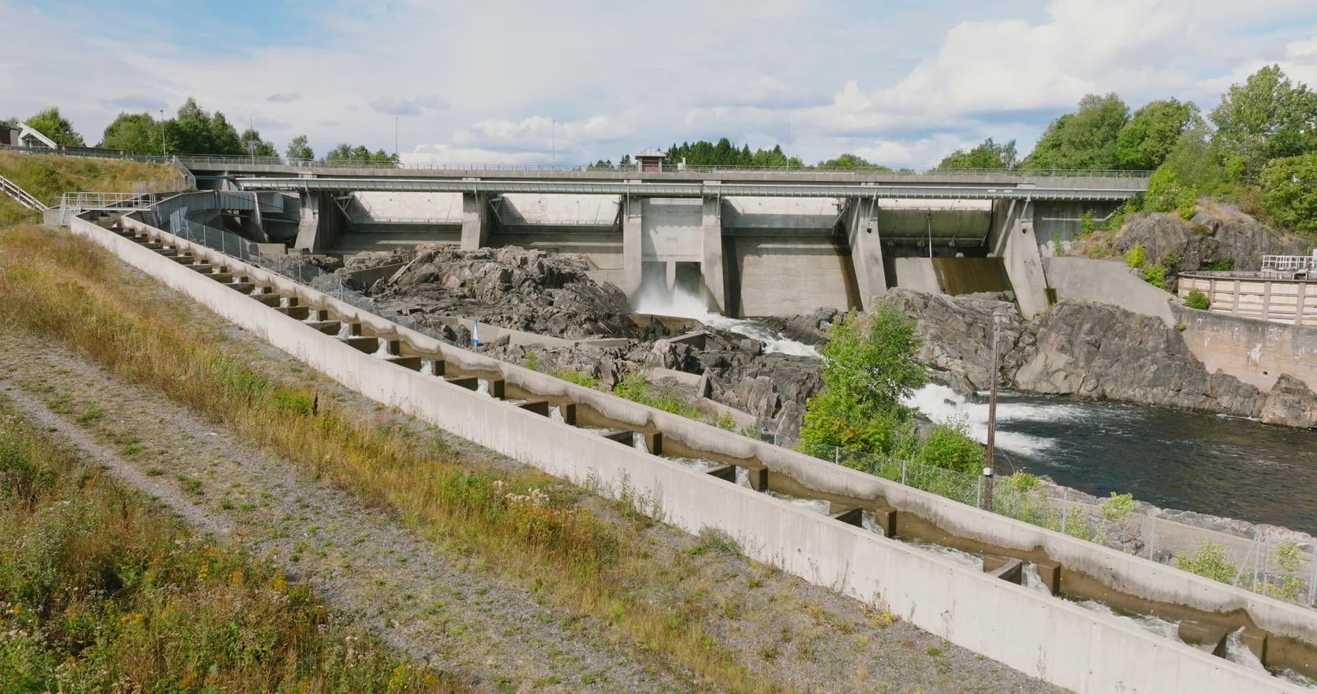 Concrete dam spillway over rocky river, Rykene, Norway