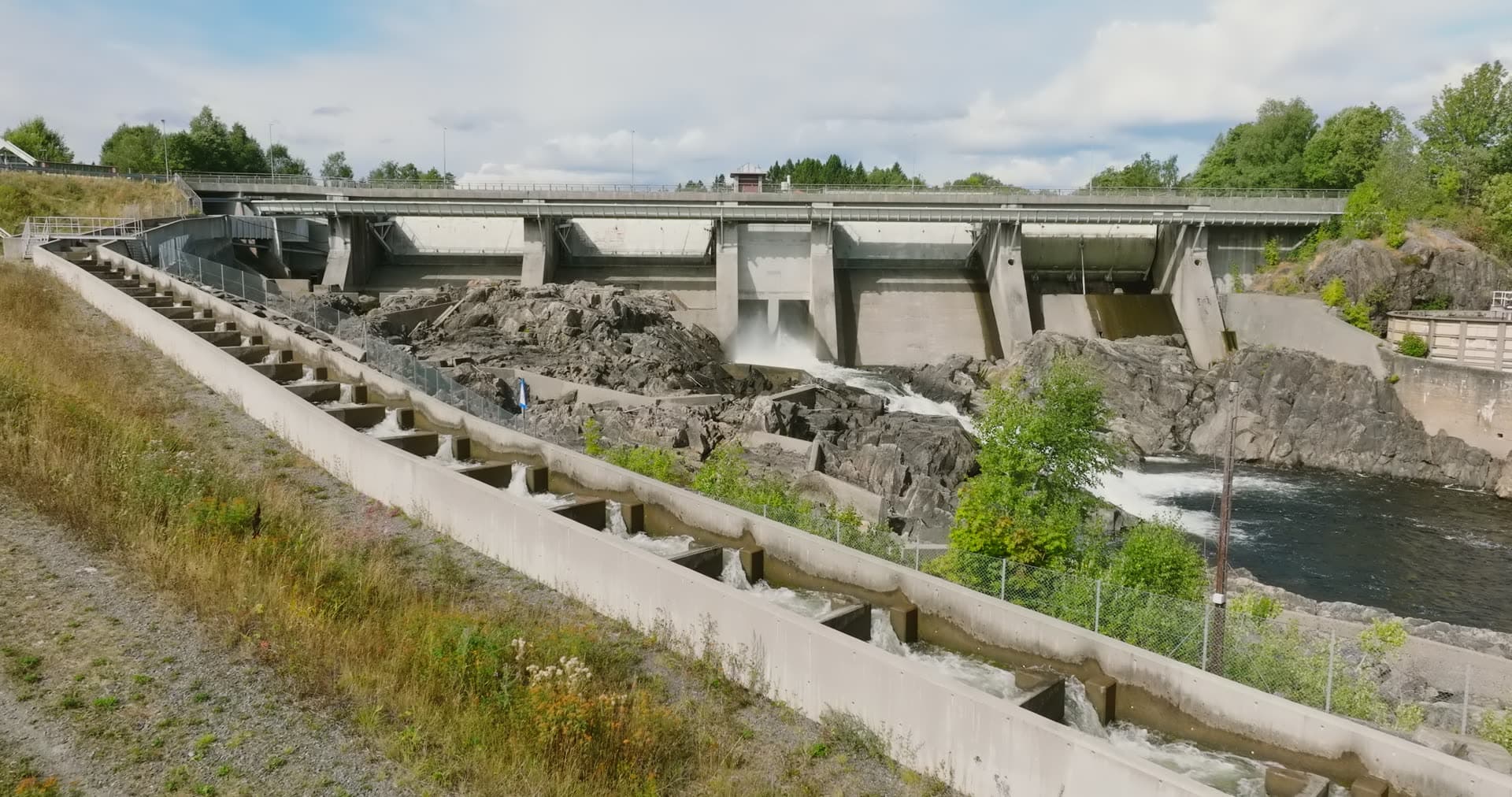 Concrete fish ladder beside river dam, Rykene, Norway