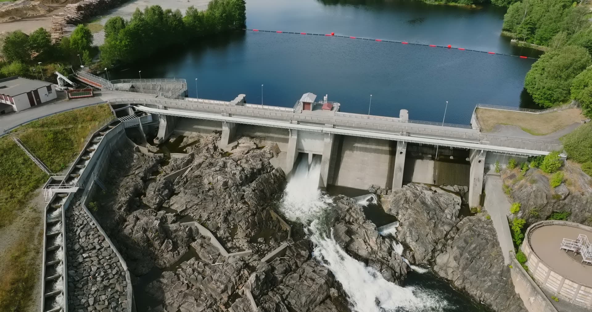 Concrete dam spilling water over rocks, Rykene, Norway