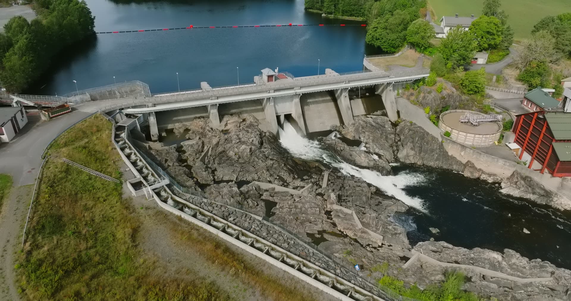 Dam spillway over bare rock and fish ladder, Rykene, Norway