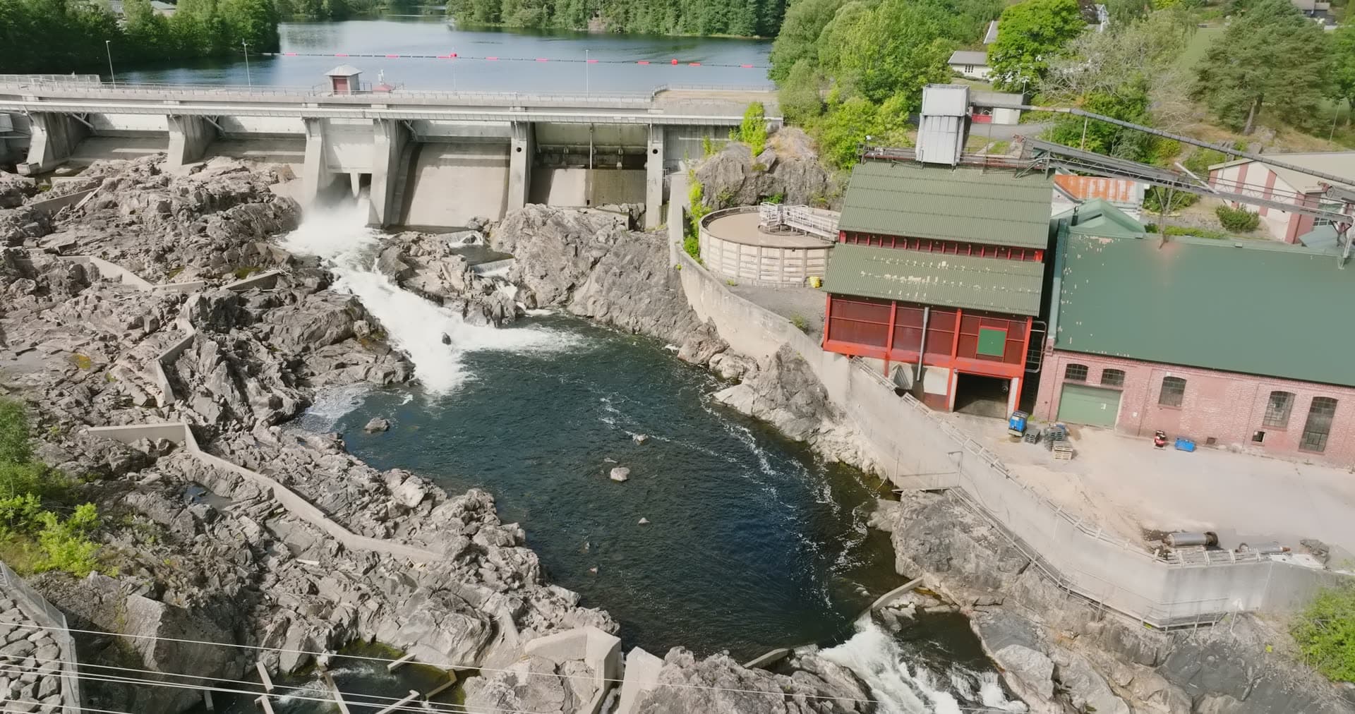 Concrete dam and red powerhouse on rocks, Rykene, Norway