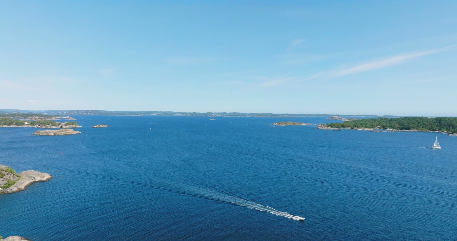 Motorboat wake crossing open archipelago, Skålevik, Norway