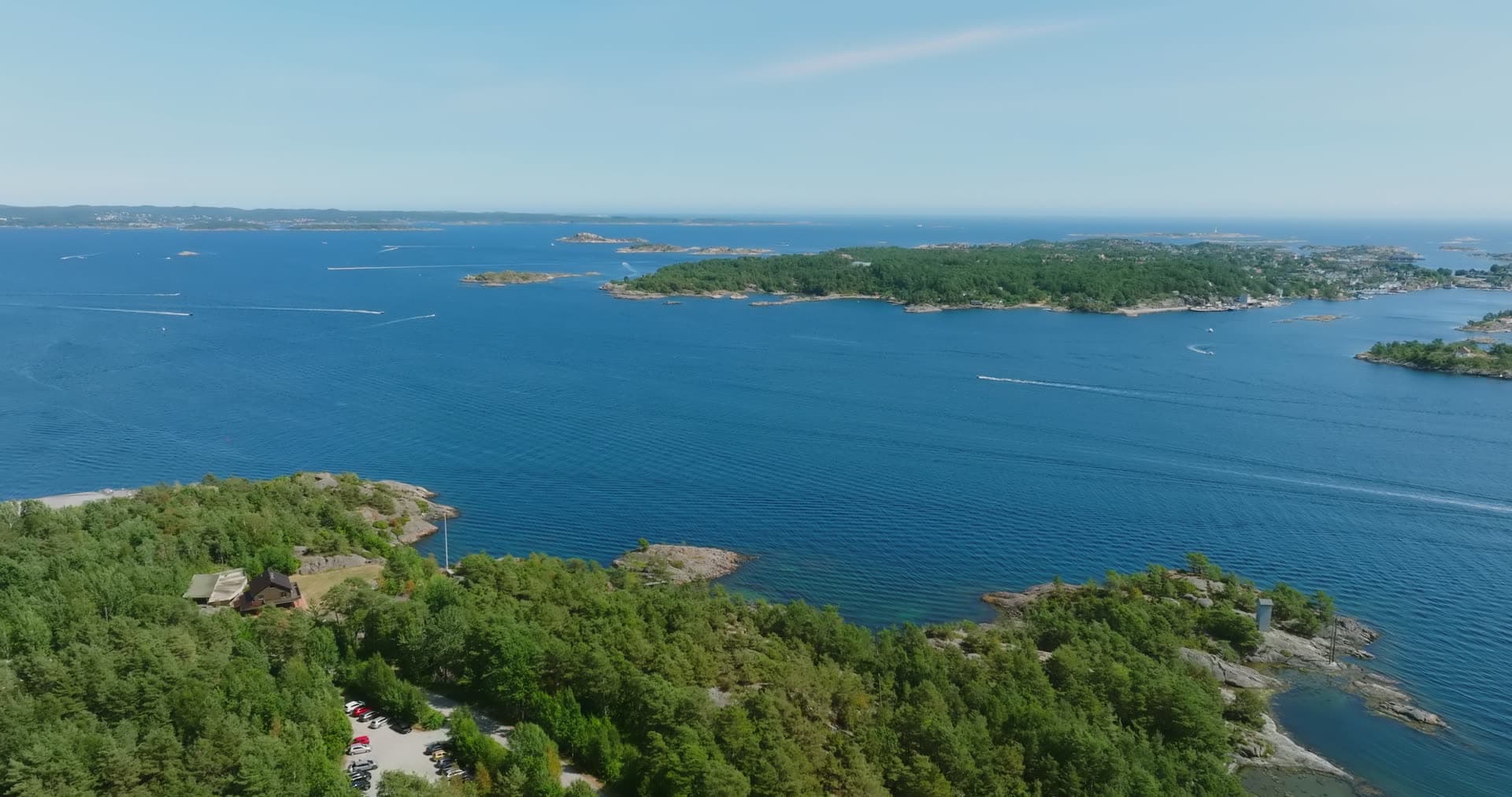 Clear shallow water over rock by a shore house, Møvik, Norway