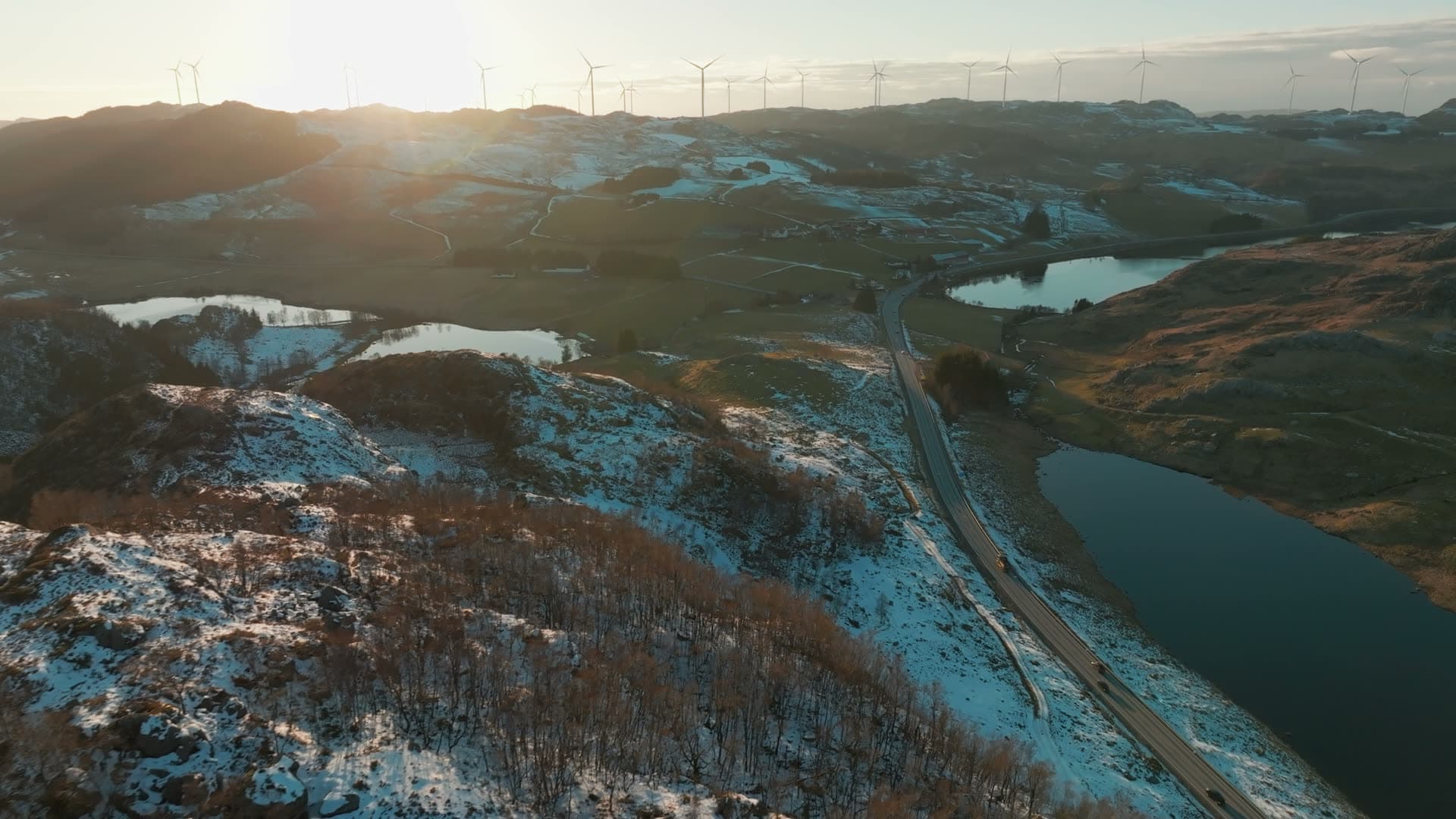 Wind turbines above road between snowy lakes, Skurvenuten, Norway