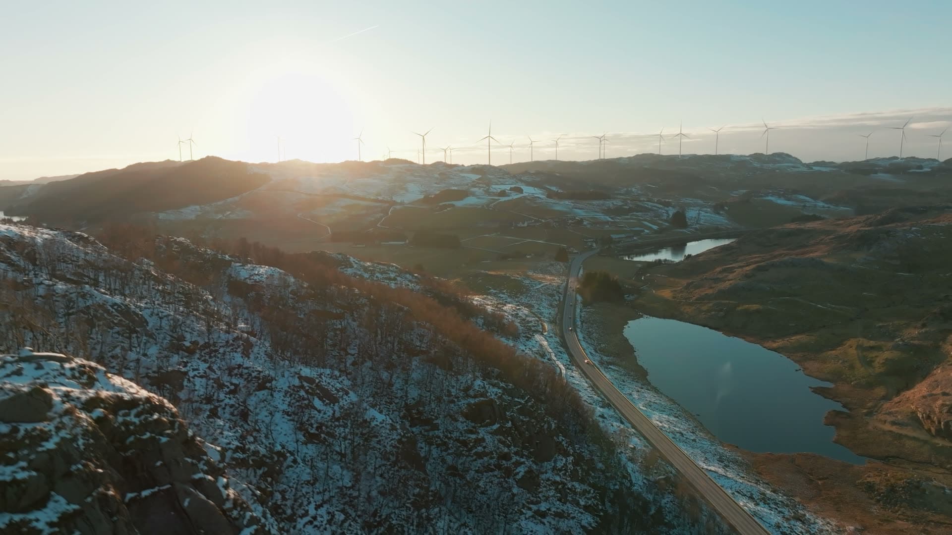Wind turbines on ridge above snowy road, Skurvenuten, Norway