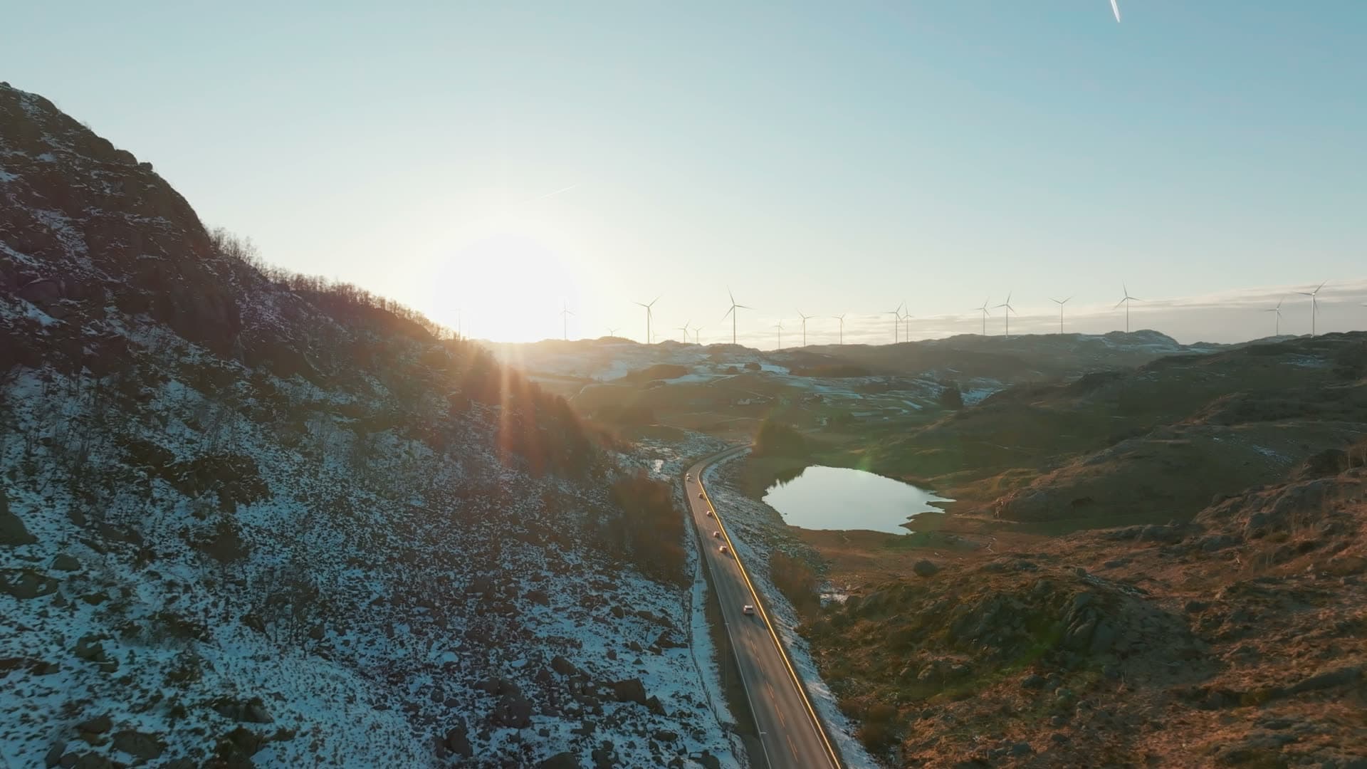 Road past small lake below wind turbines, Skurvenuten, Norway