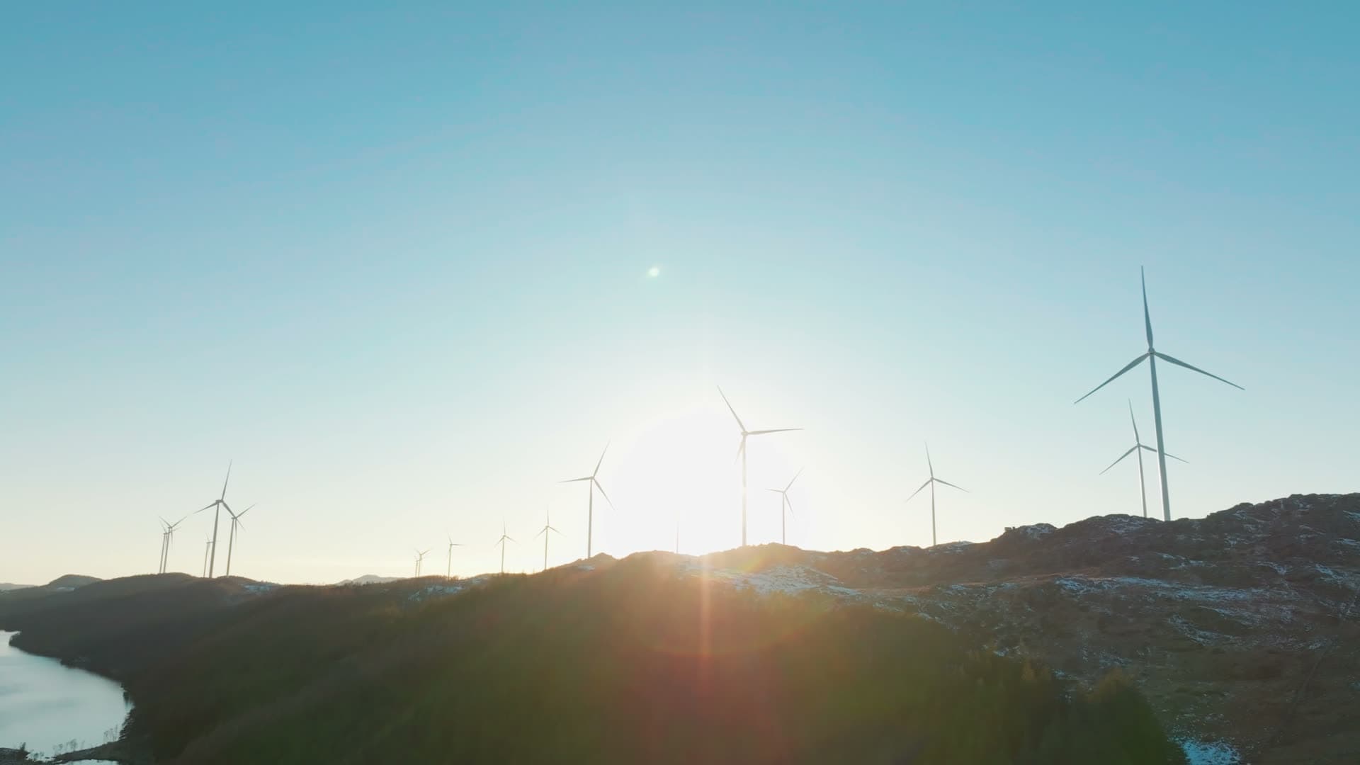 Wind turbine row on ridge into low sun, Skurvenuten, Norway