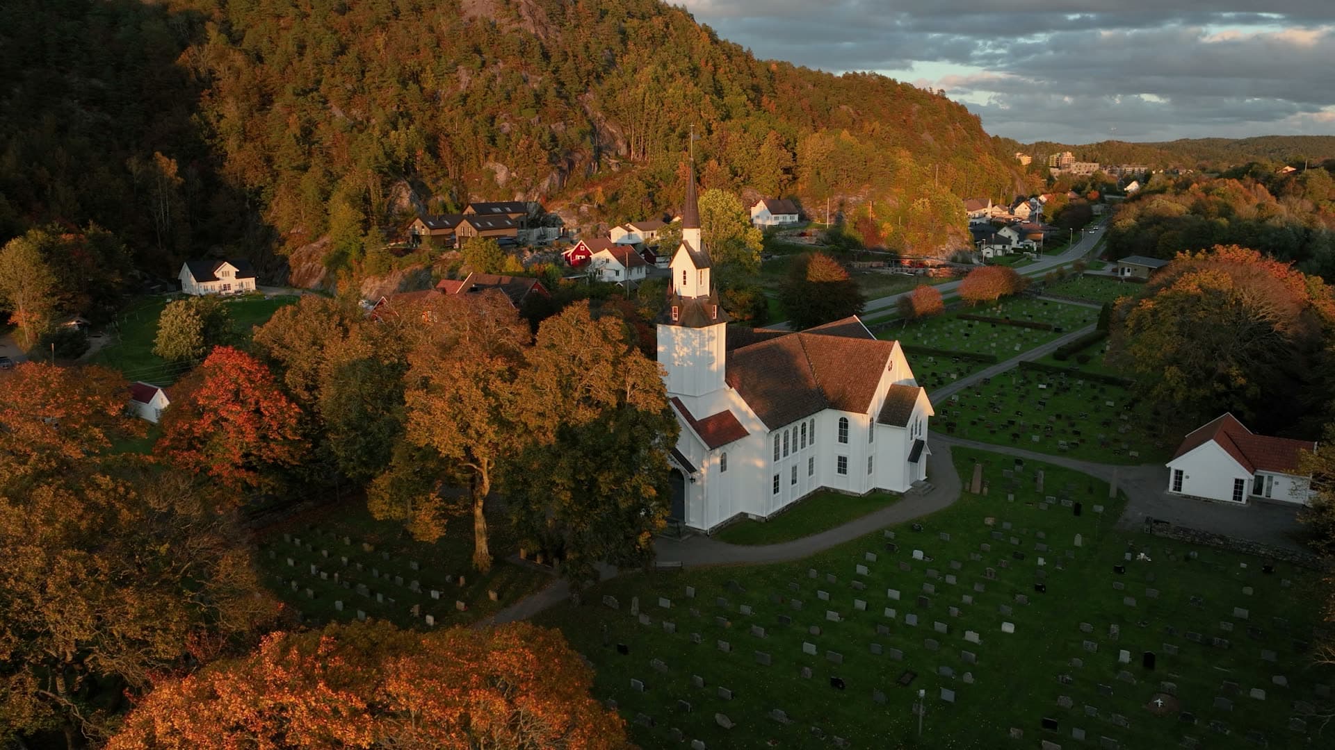 White wooden church and graveyard at sunset, Søgne, Norway