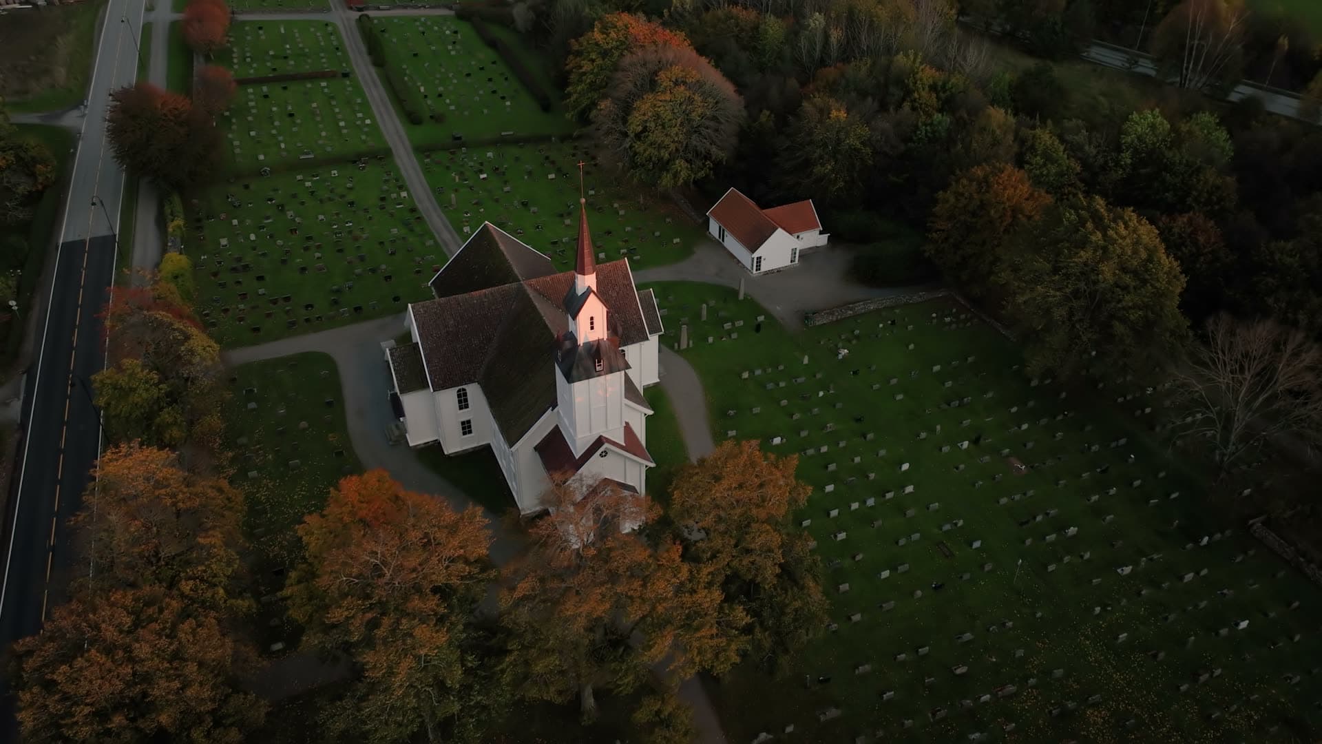 White church and graveyard in autumn light, Søgne, Norway