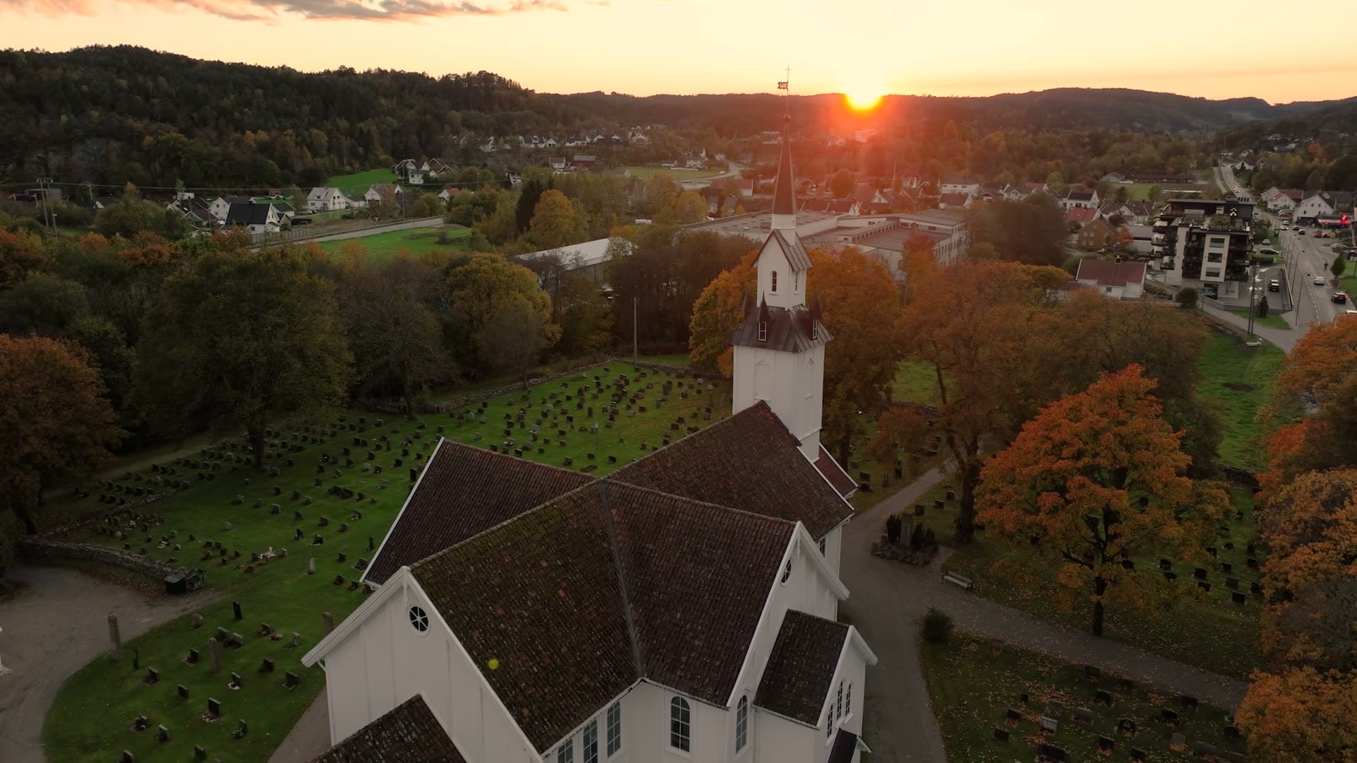 White wooden church and graveyard at sunset, Søgne, Norway