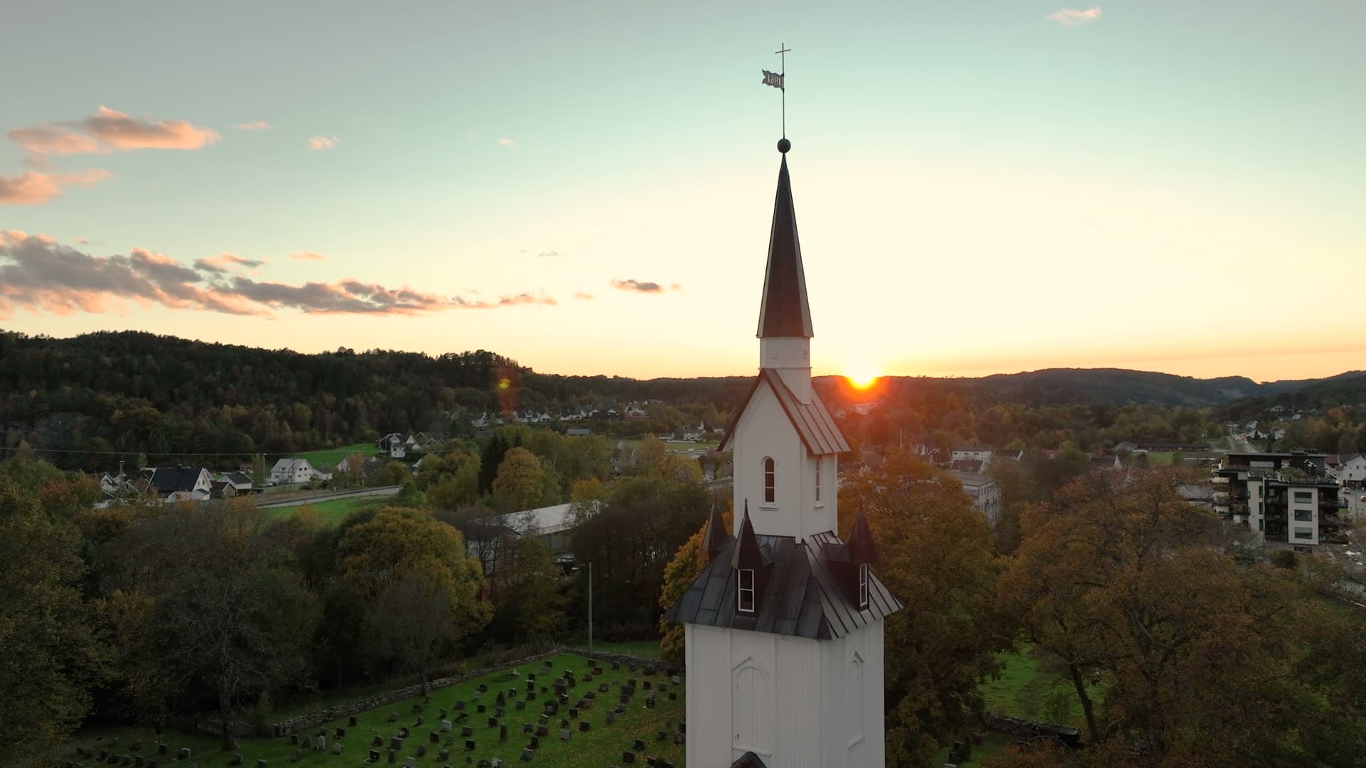 White church spire and graveyard at sunset, Søgne, Norway