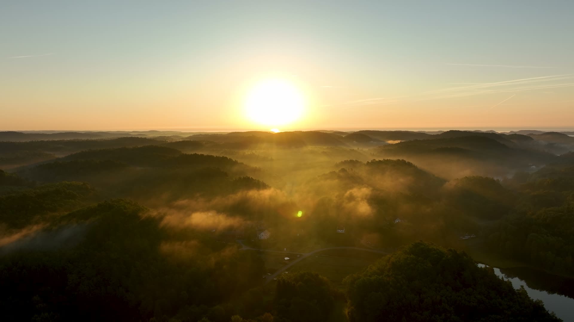 Sunrise over mist-filled forested hills, Søm, Norway