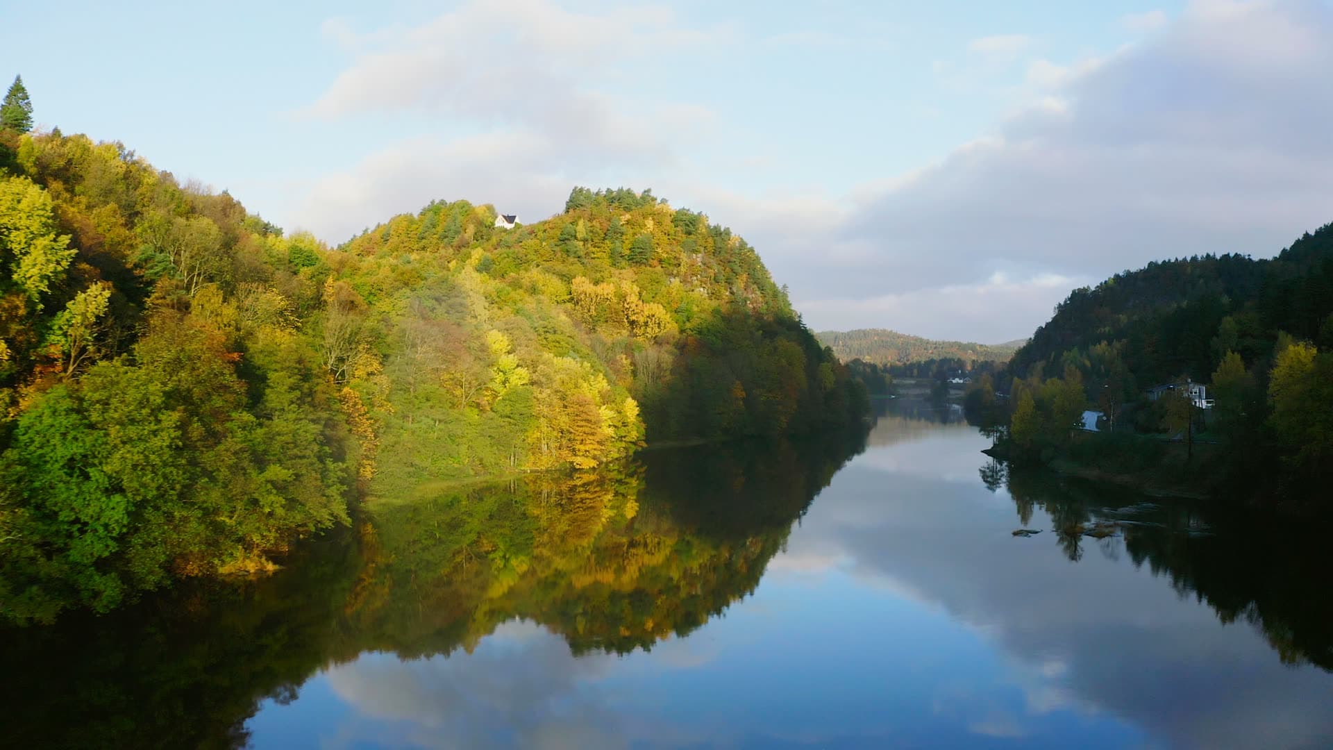 Autumn hillsides mirrored in still river, Strai, Norway