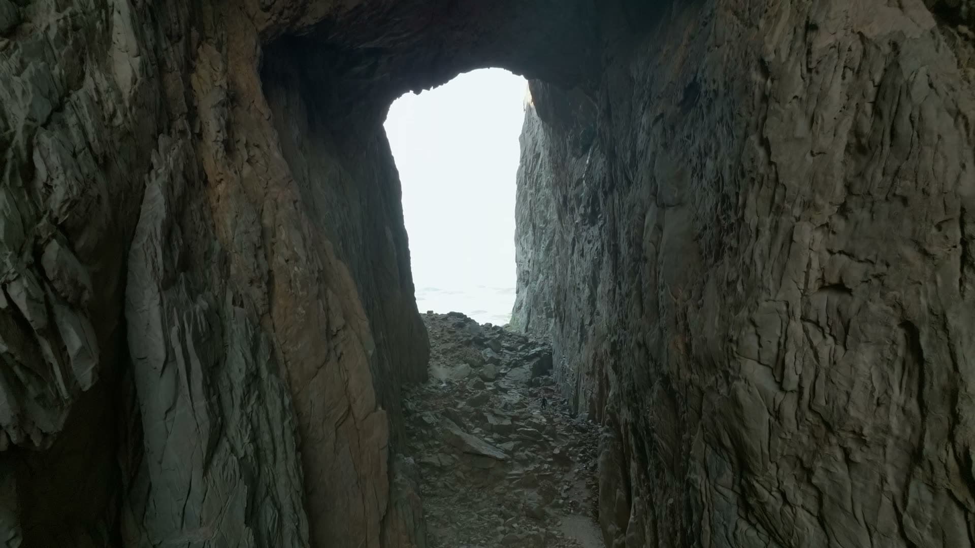 Flying through rock tunnel toward sea, Torghatten, Norway