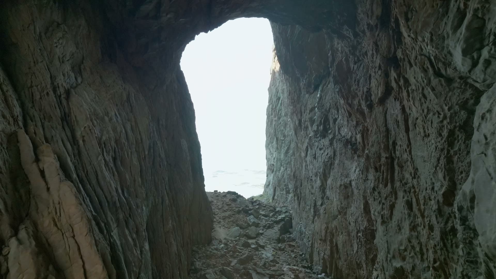 Flight through rock tunnel toward sea, Torghatten, Norway