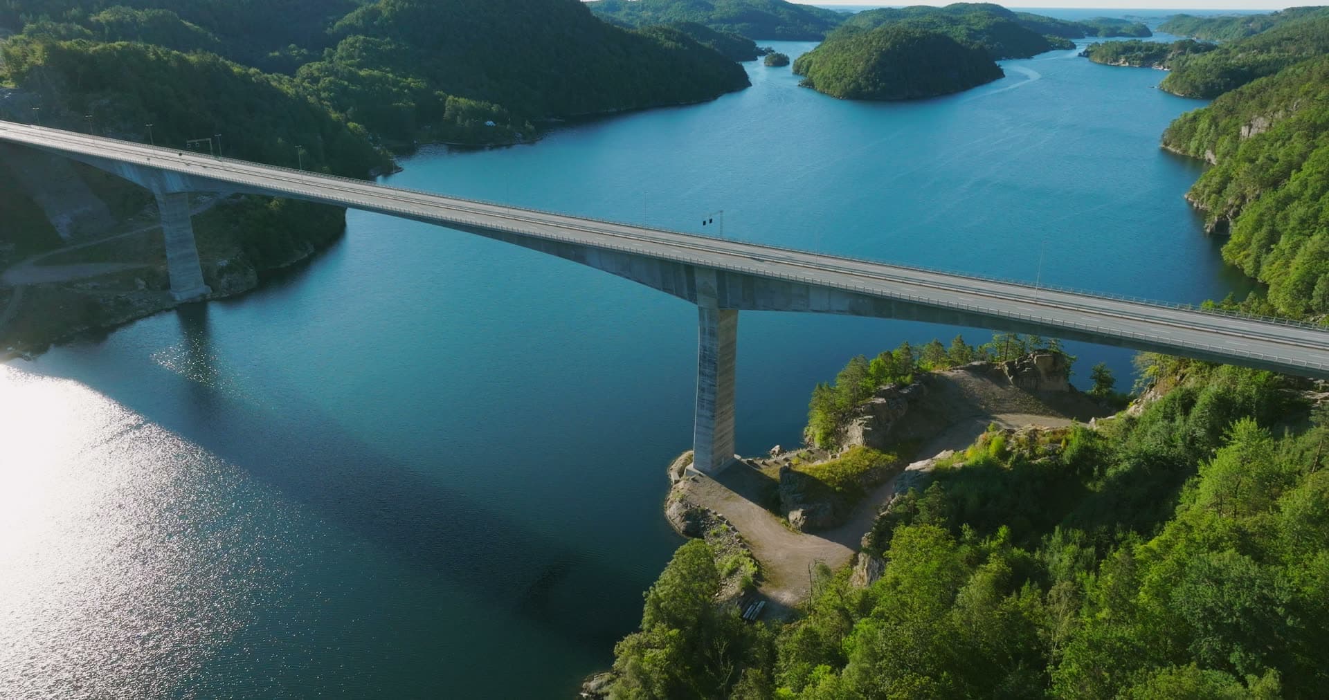 Sun glare on water beside bridge piers, Trysfjordbrua, Norway