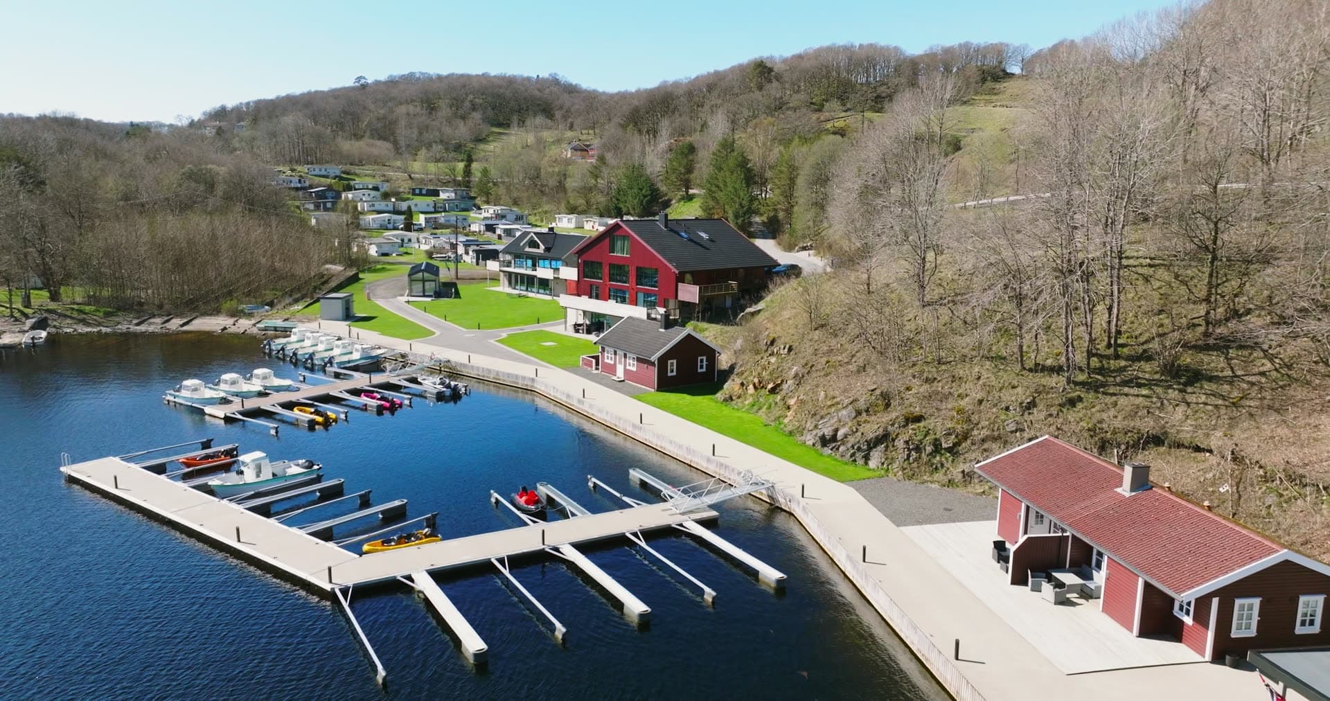 Small-boat marina below red timber lodge, Vanse, Norway