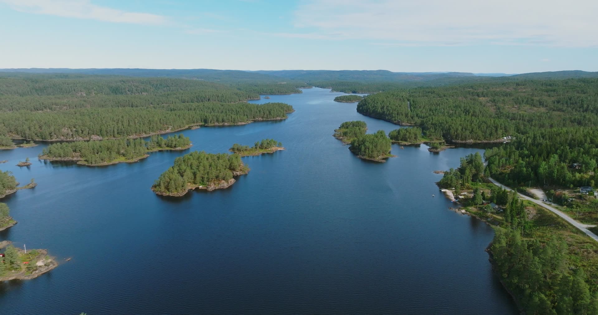Forested lake islets and shoreline road, Vassbotn, Norway