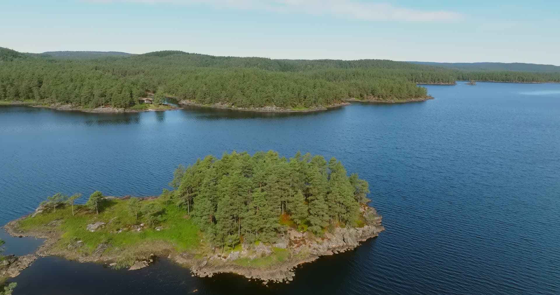 Pine-covered lake island with rocky shore, Vassbotn, Norway
