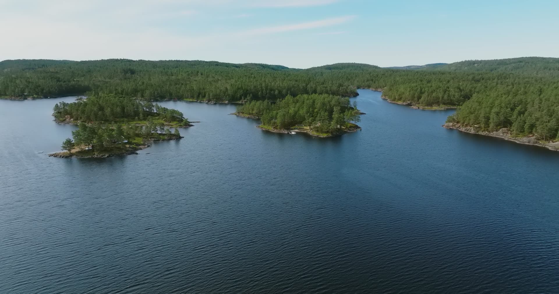Pine islets and a lone cabin on a lake, Vassbotn, Norway