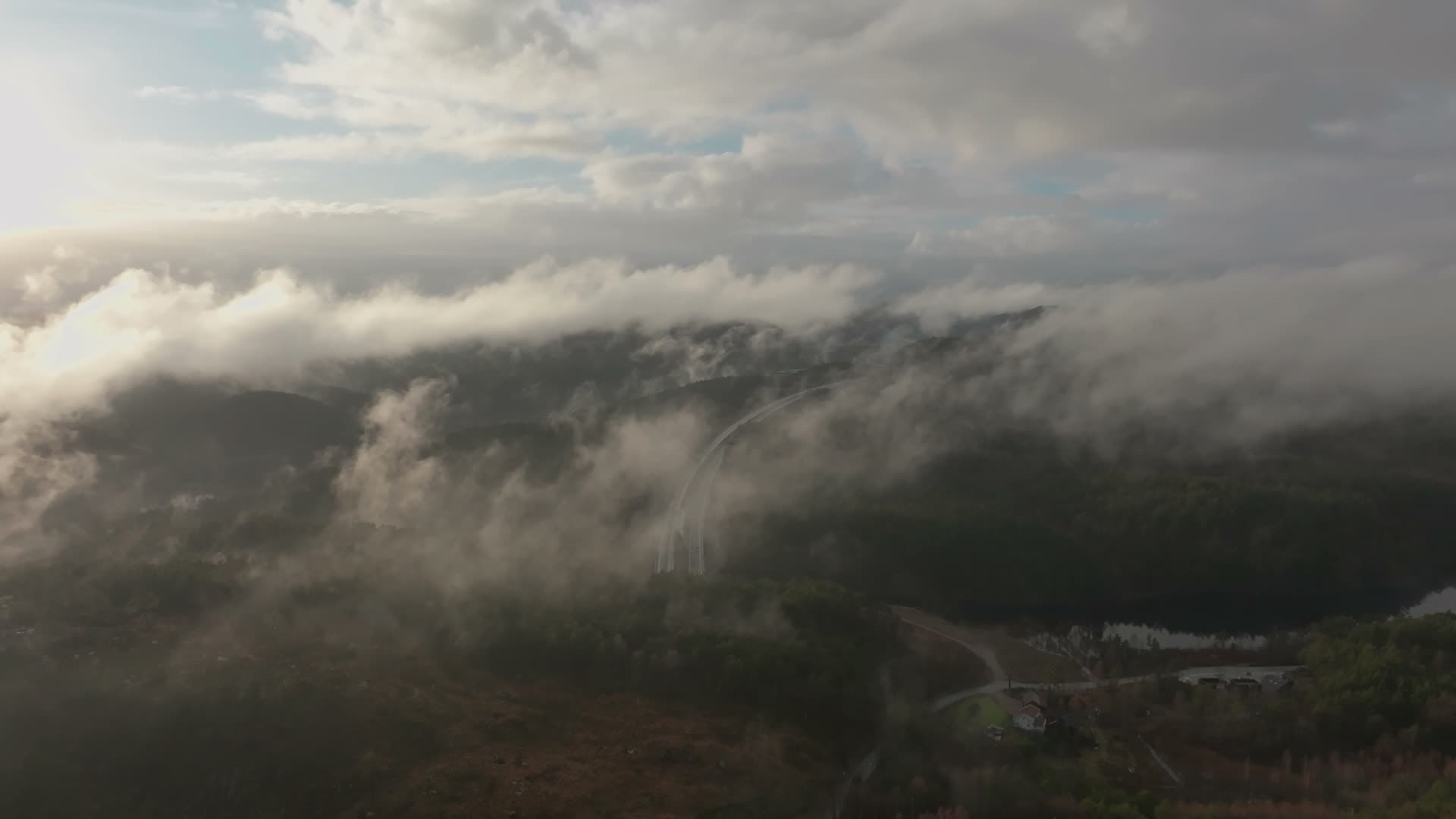 Low clouds over wooded ridge and housing, Vedderheia, Norway