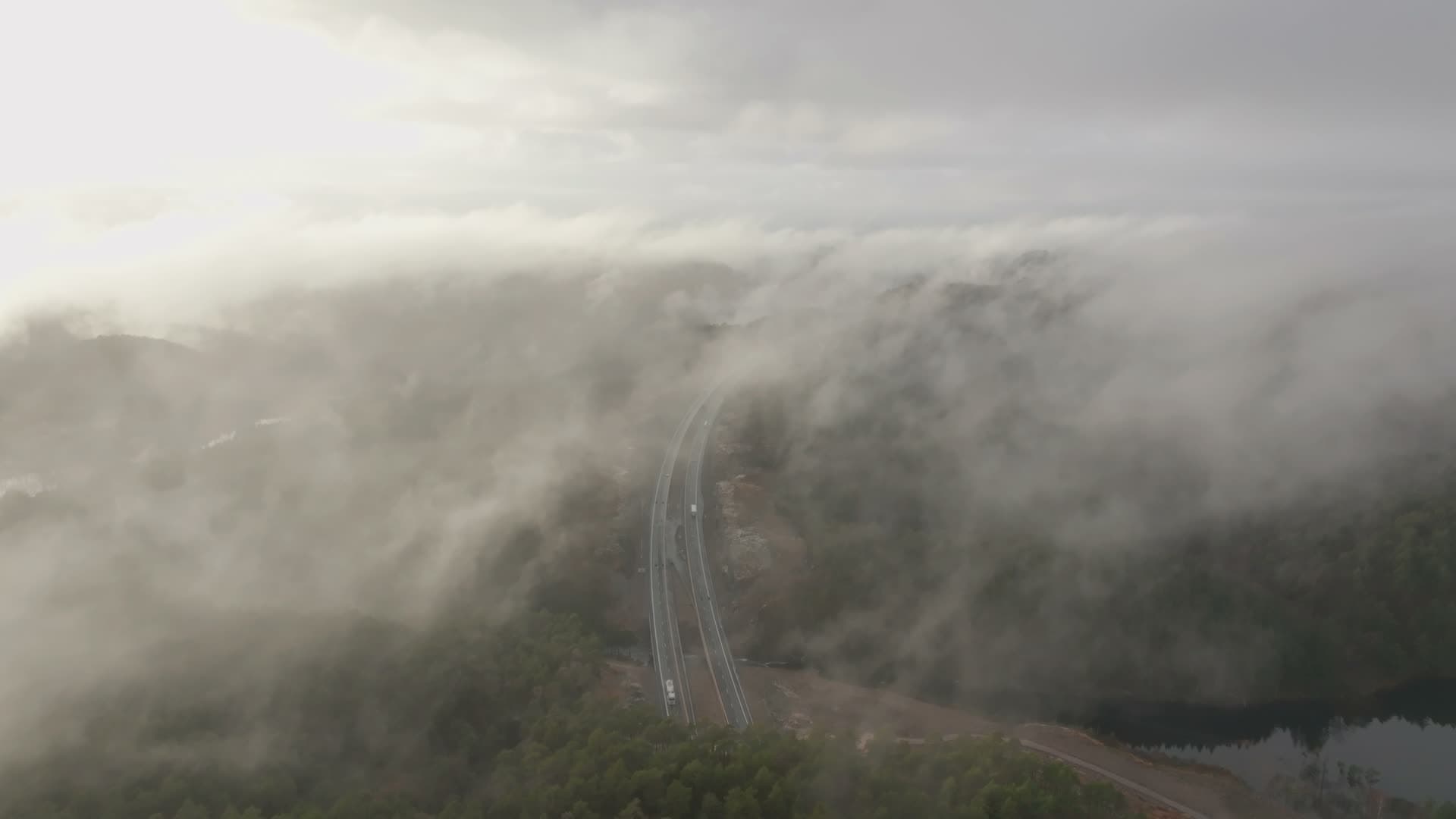 Trucks on curving viaduct below cloud deck, Vedderheia, Norway
