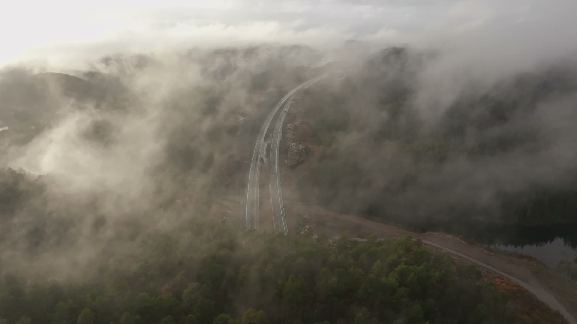 Low cloud drifting over curved highway, Vedderheia, Norway