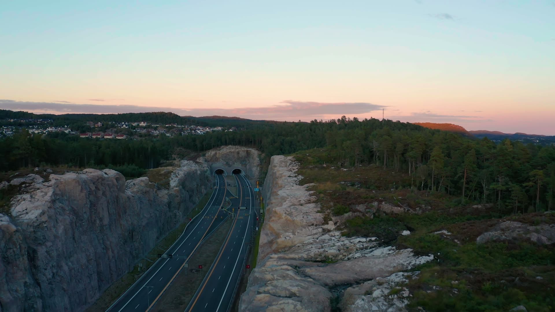 Twin tunnel portals in rock cut at dusk, Vedderheia, Norway