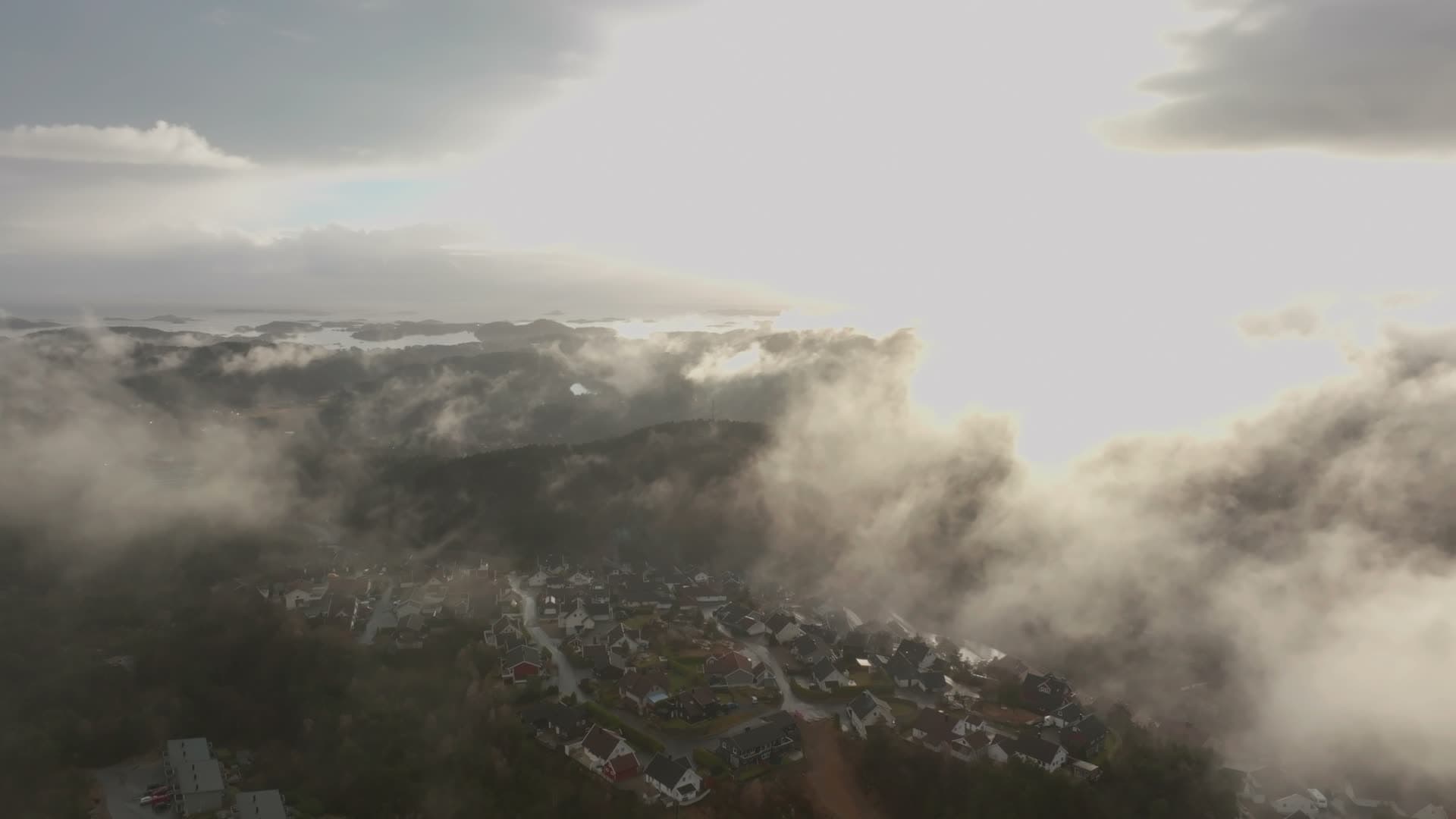 Low clouds drifting over hillside housing, Vedderheia, Norway