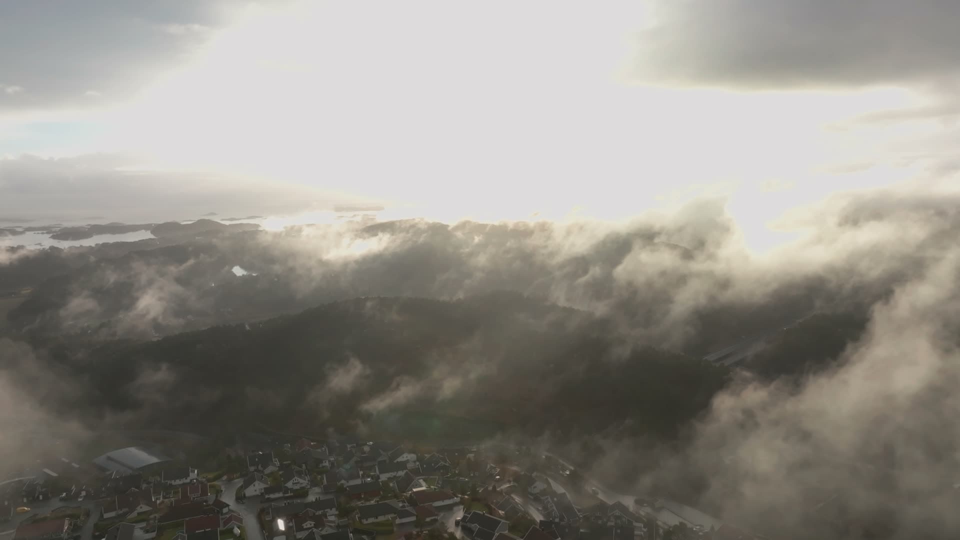 Flying through low cloud over hillside houses, Vedderheia, Norway