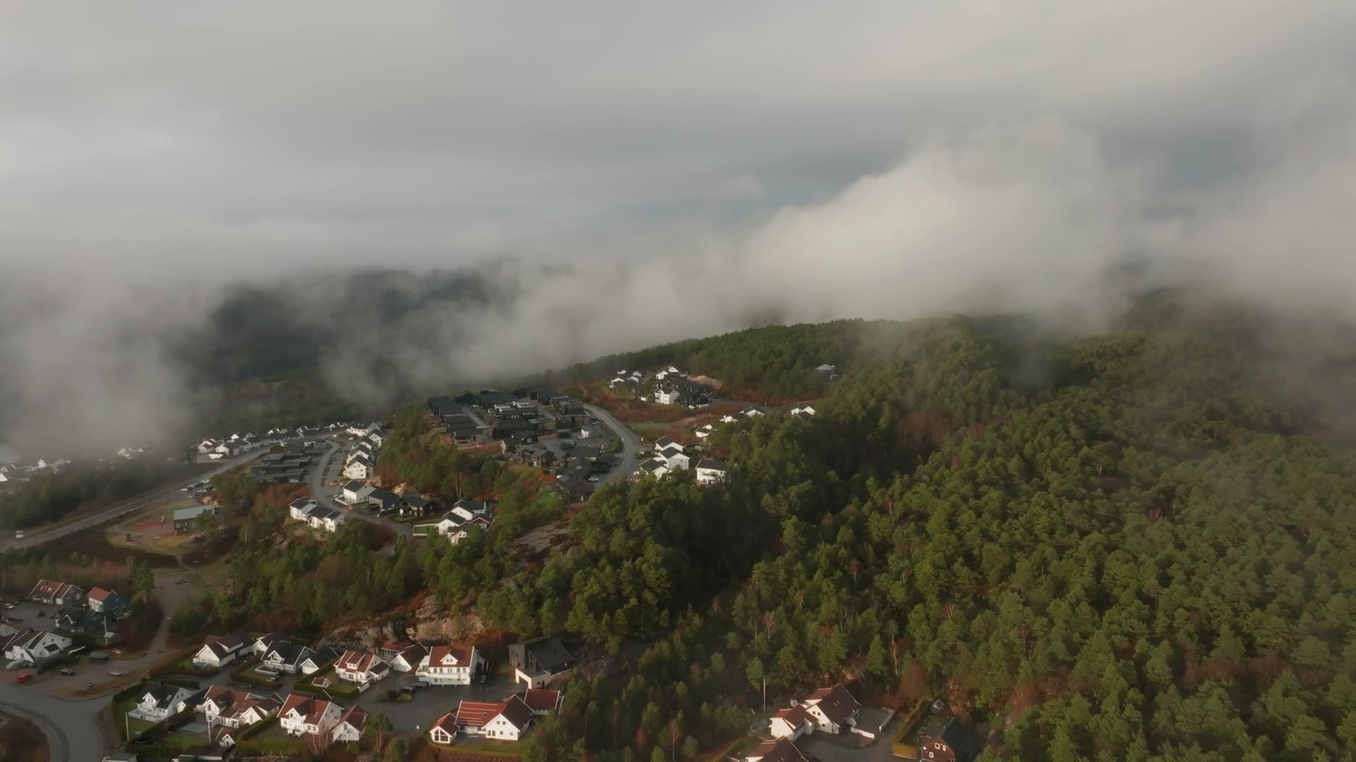 Low cloud drifting over hillside housing, Vedderheia, Norway