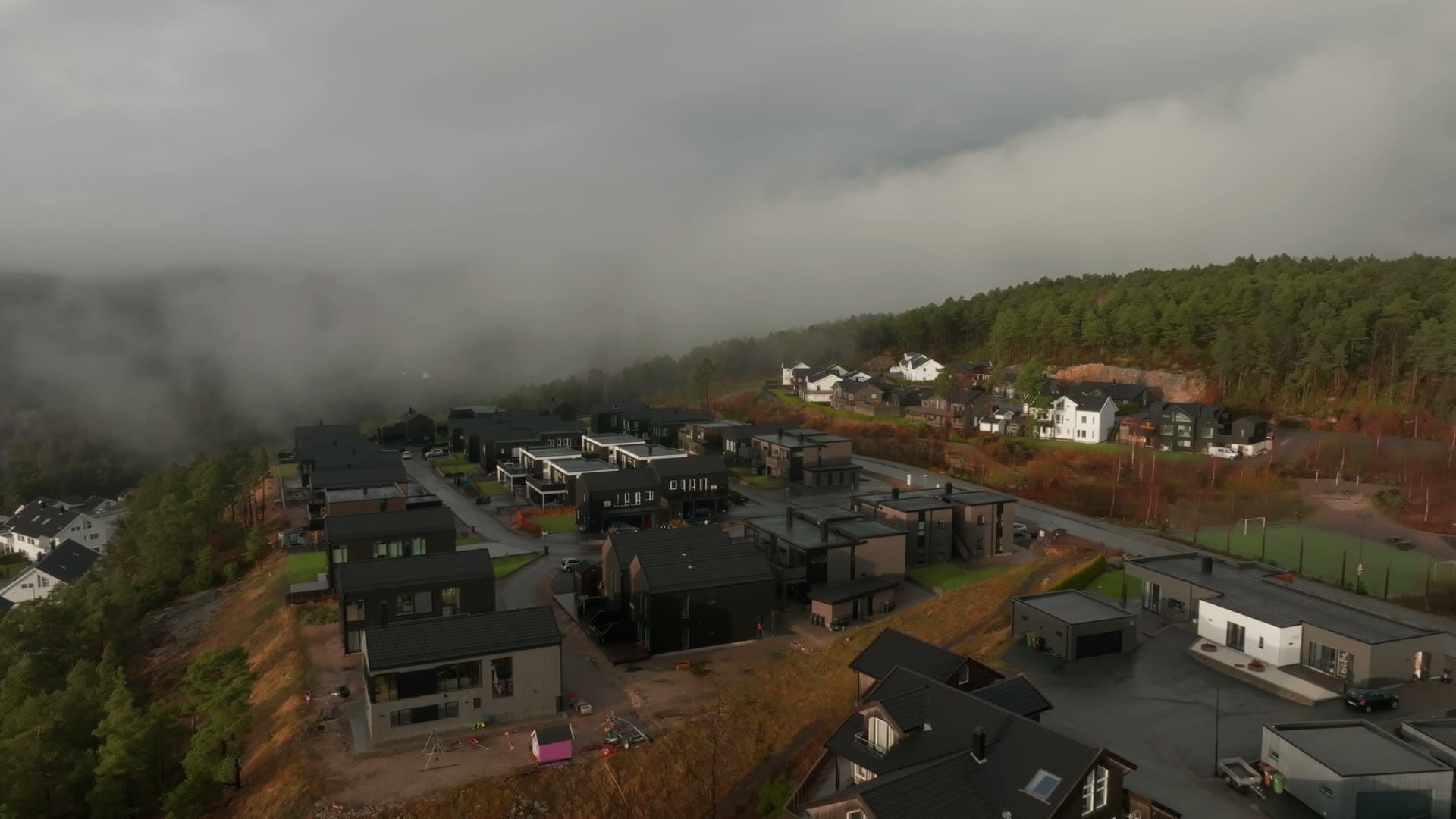 Low fog over new black-clad housing estate, Vedderheia, Norway