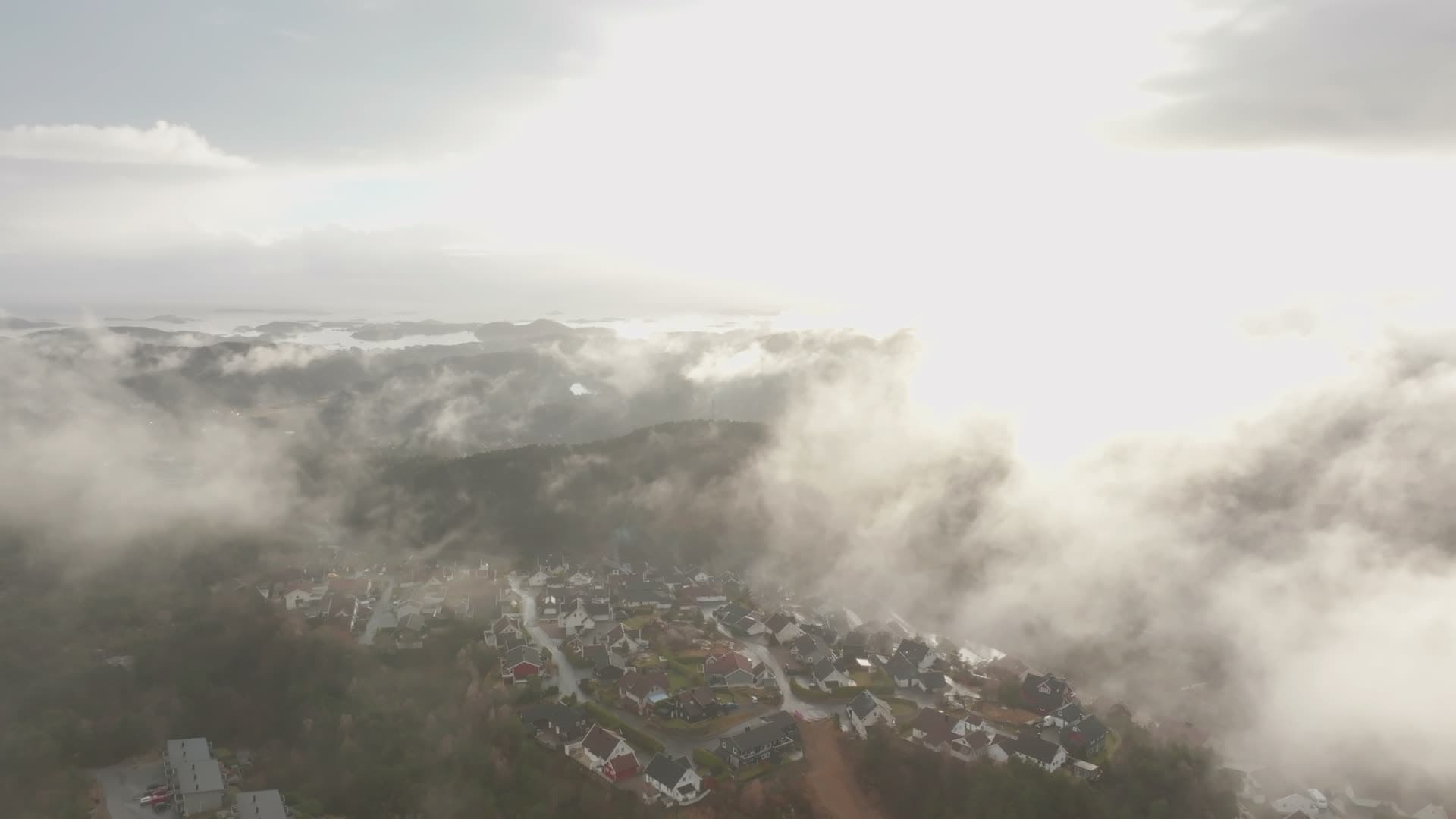 Cloud bank splitting to reveal rooftops, Vedderheia, Norway
