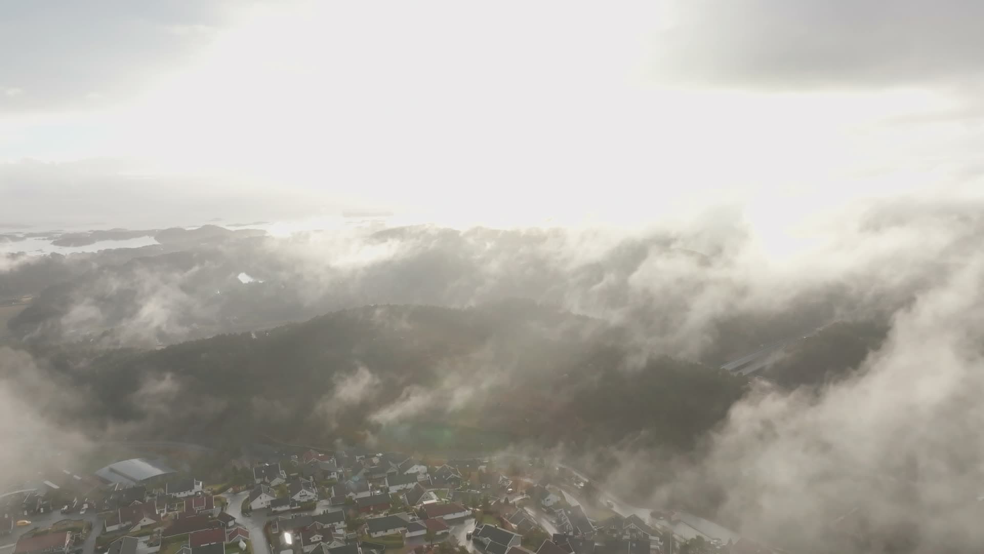 Sun burst through cloud gaps over ridge, Vedderheia, Norway