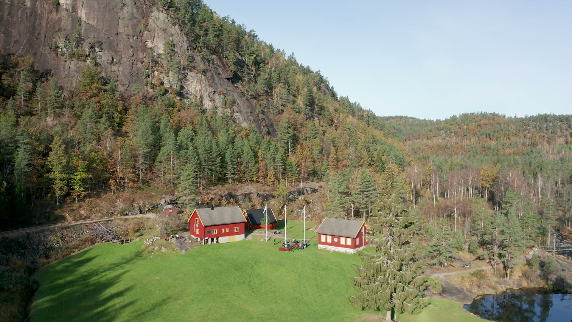Red farm buildings below a rock cliff, Vennesla, Norway