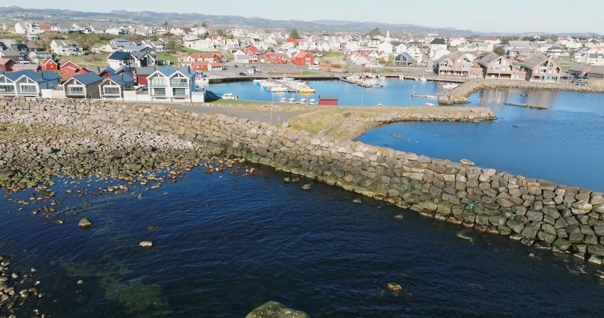 Rock breakwater sheltering small boat harbour, Vestbygd, Norway