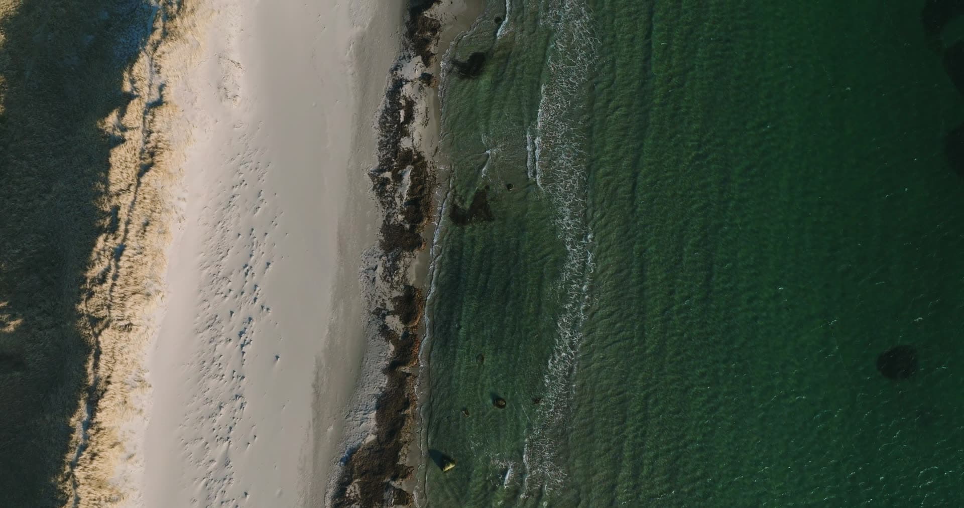 Top-down surf line on white sand beach, Vestbygd, Norway