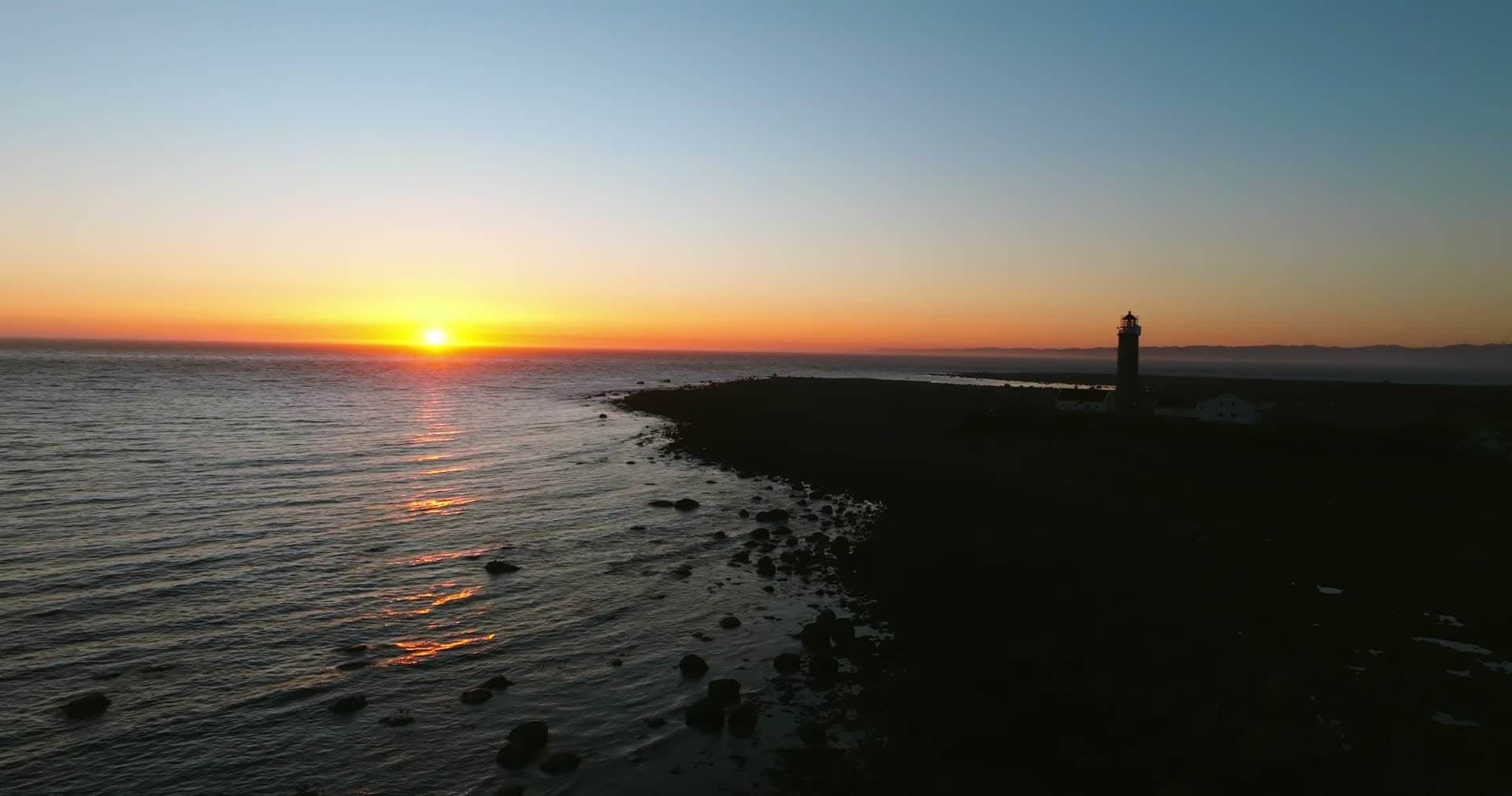 Lighthouse on rocky point at sunset, Vestbygd, Norway