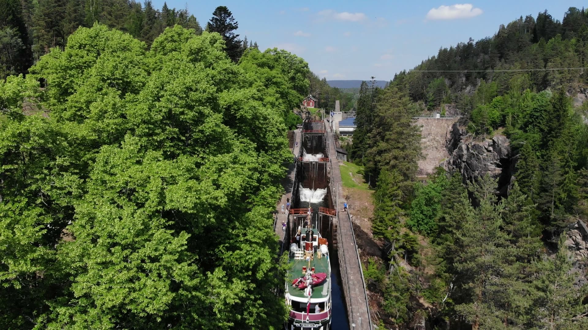 Lock stairway between leafy trees and cliff, Vrangfoss, Norway